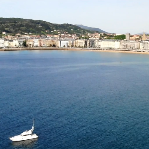 Vista aérea de la bahía de La Concha en San Sebastián, con aguas turquesas y arena blanca.