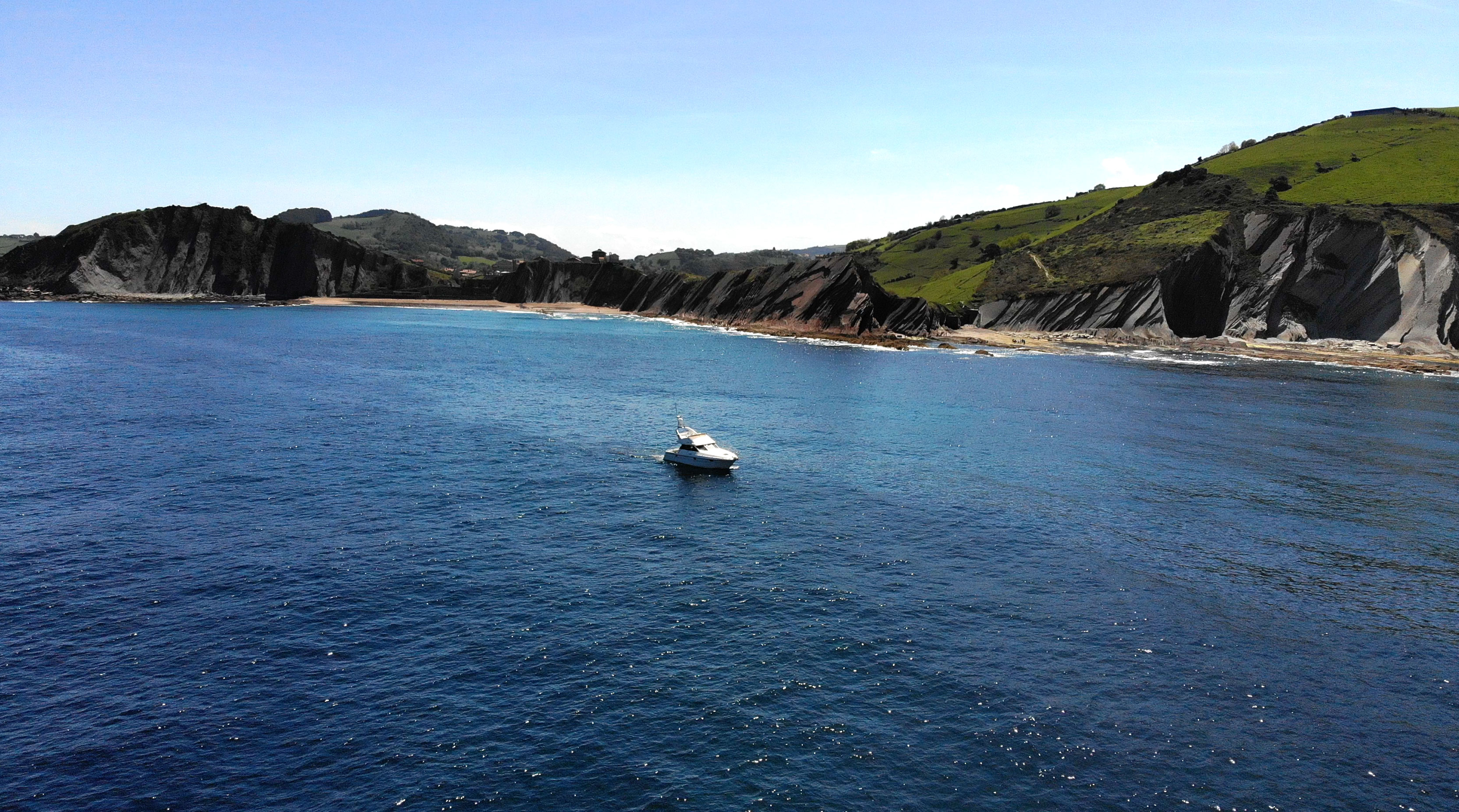 Luxury yacht cruising along the stunning flysch coastline of the Basque Country near Getaria.